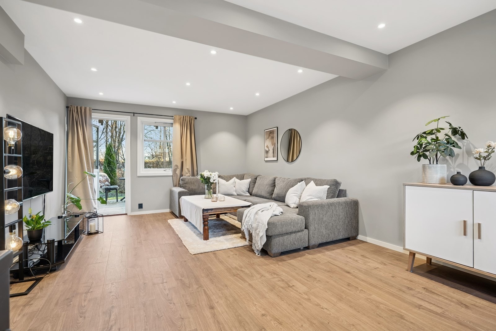 Vi beveger oss videre inn i en lys og svært innbydende stue. Det ble byttet gulv i leiligheten i 2023. Galleribilde