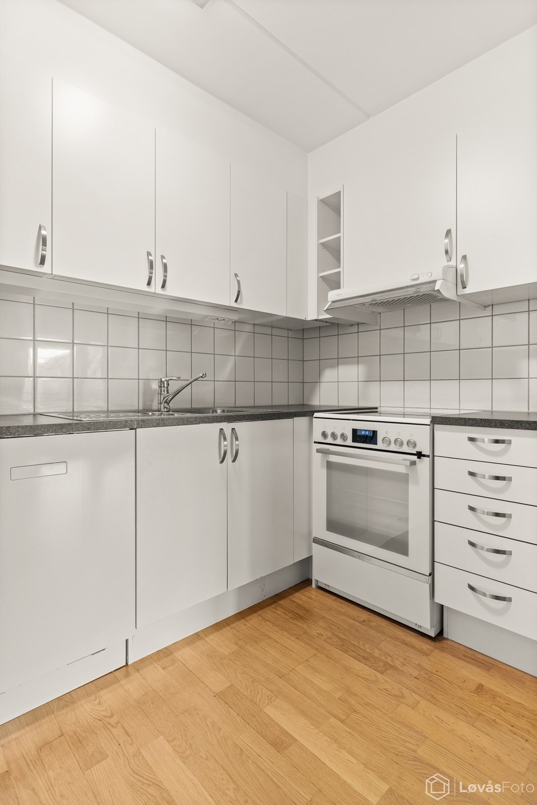 Foilerte fronter, laminert benkeplate og praktisk belysning under overskapene - et kjøkken som er enkelt å vedlikeholde. Galleribilde