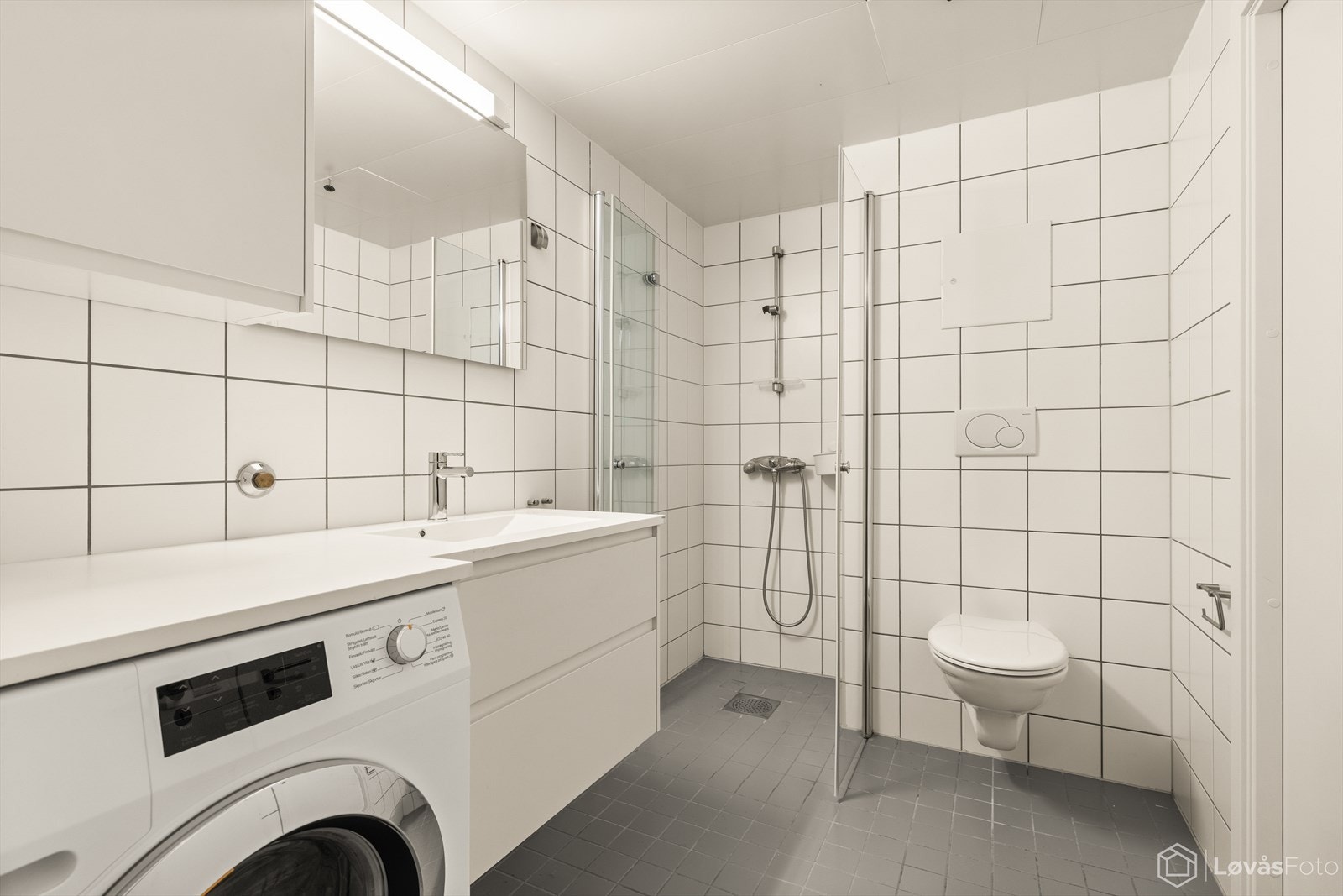 Badet består av blant annet dusjhjørne med foldedør på en side, downlights i taket og varmekabler i gulvet. Galleribilde