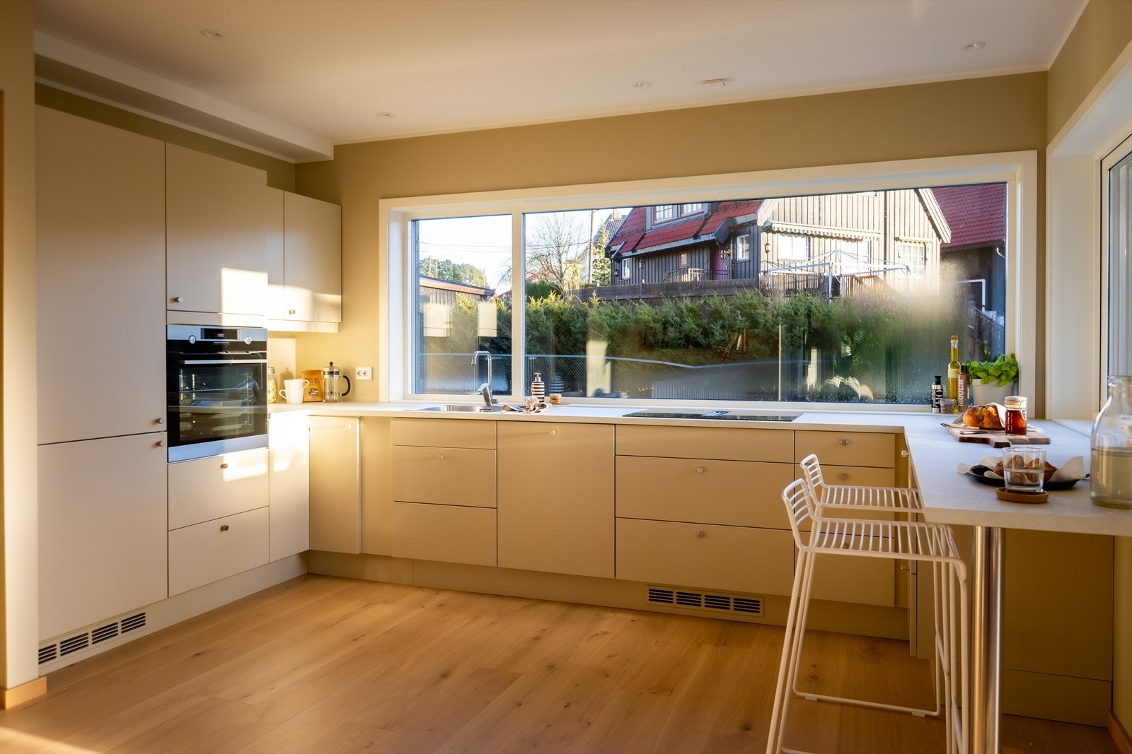 Kjøkkenet har lys innredning med slette fronter og laminat benkeplate med limt oppvaskkum i stål og ettgreps blandebatteri. Galleribilde