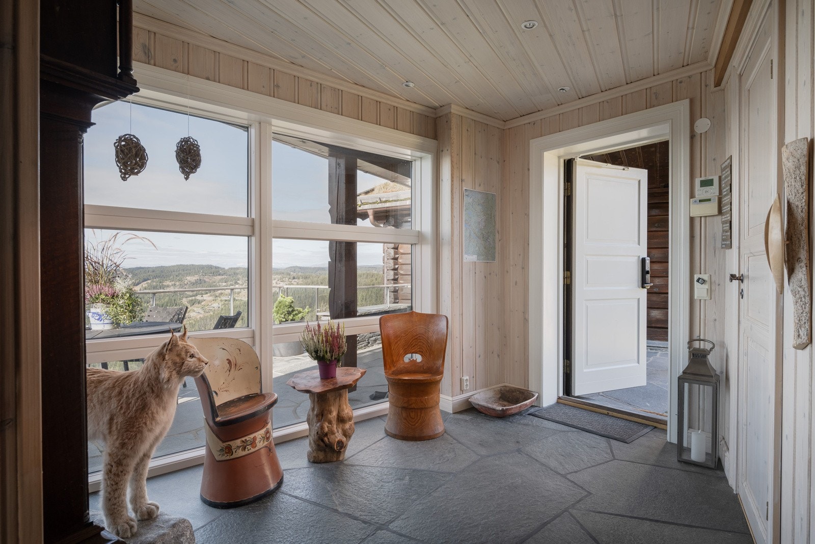 I første etasje finner du en flott entré med synlige tømmervegger og stilren skifer - lun velkomst inn i hytta Galleribilde