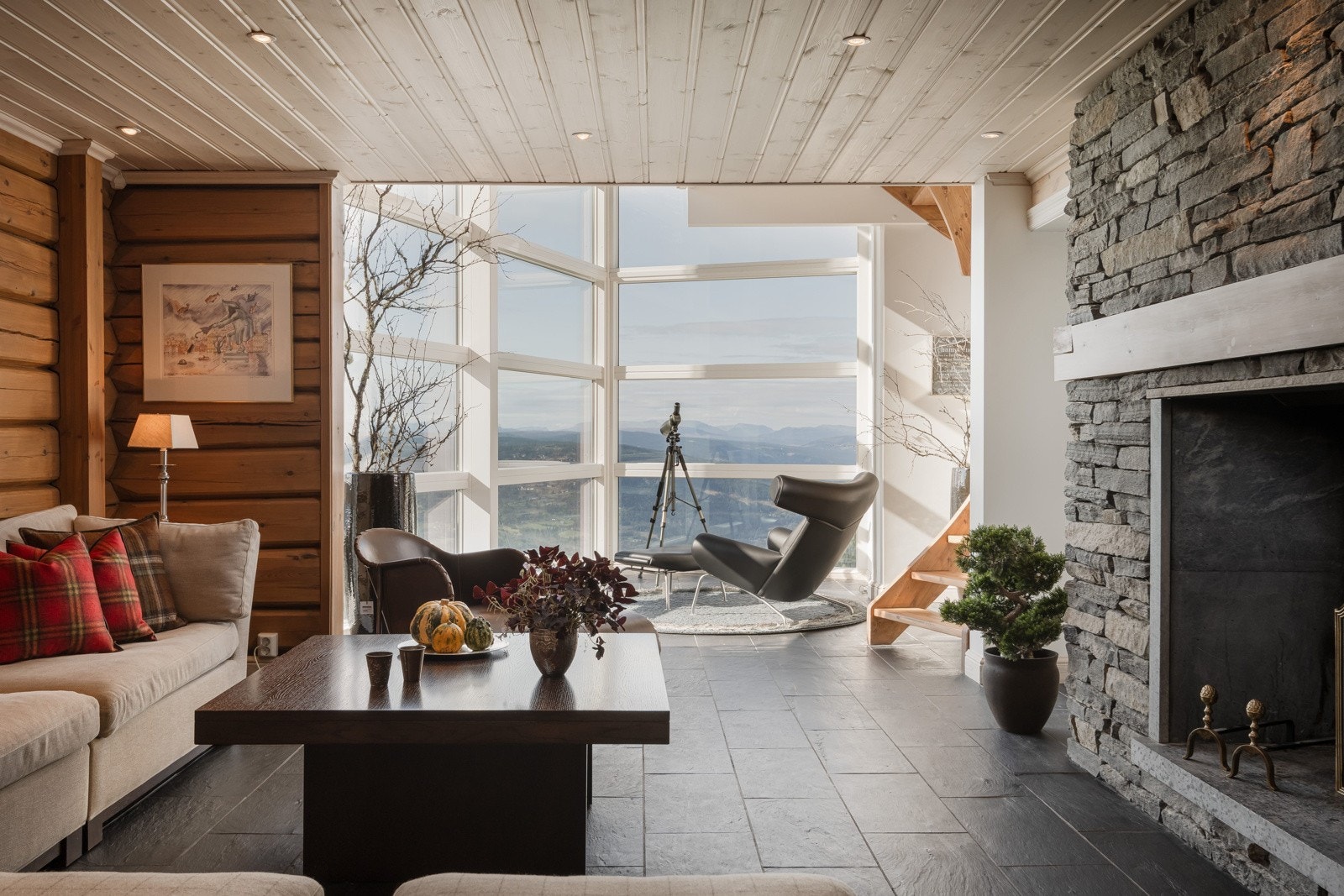 Her finner du et romslig oppholdsområde med naturlig lys, med åpent inn til vinterhagen hvor vindusrekken er fra gulv i underetasje til himling i første etasje Galleribilde