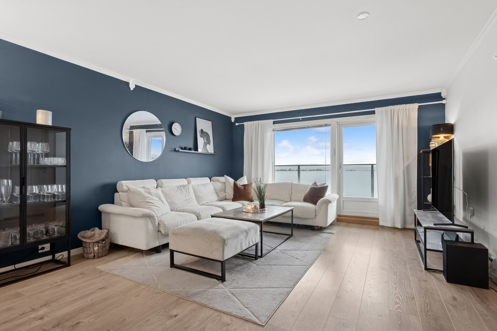 Pen stue som har store vindusflater som gir mye naturlig lysinnslipp og bidrar til en behagelig romfølelse. Galleribilde