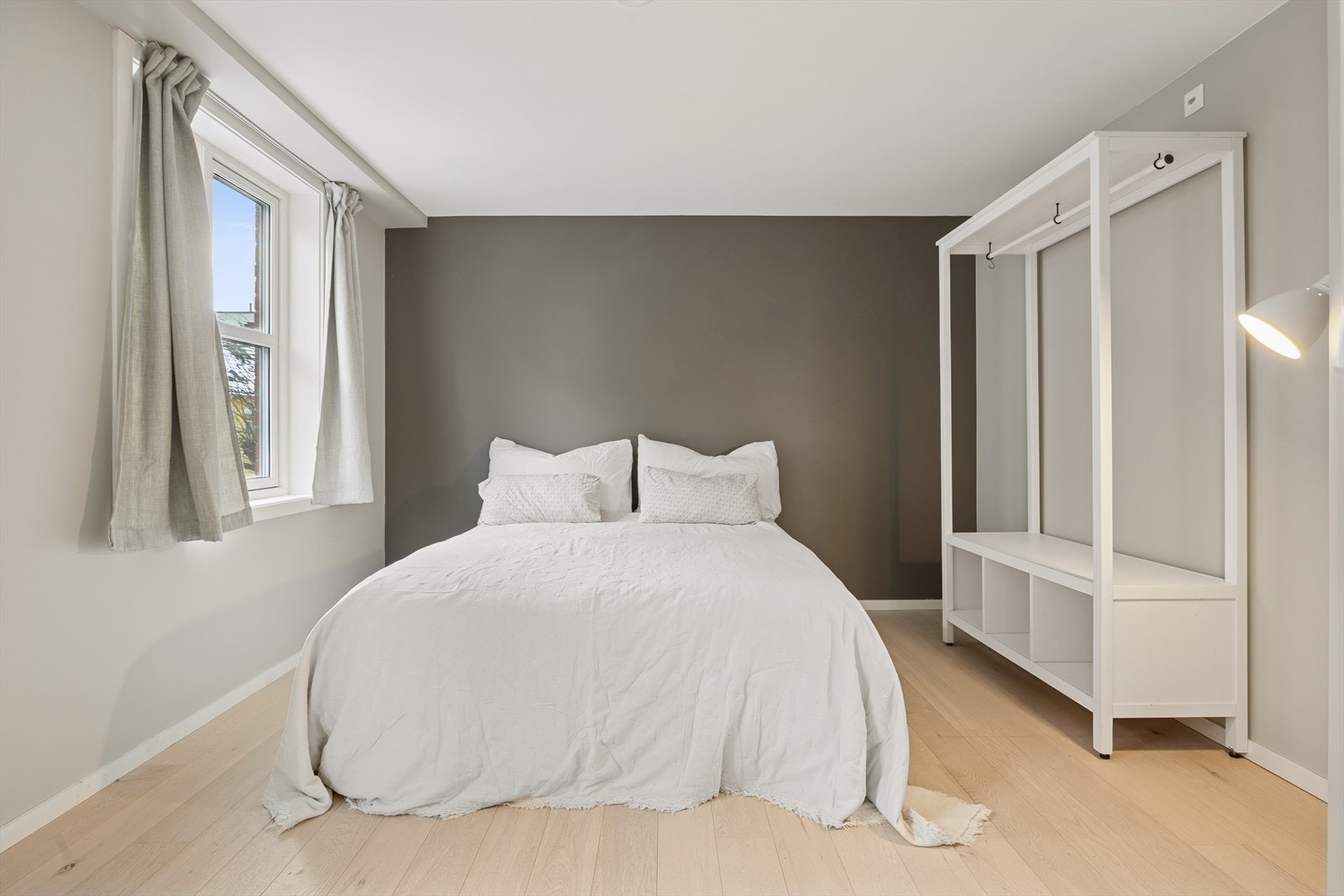 Stort soverom i lyst toner med god plass til garderobe og tilhørende møblement. Galleribilde