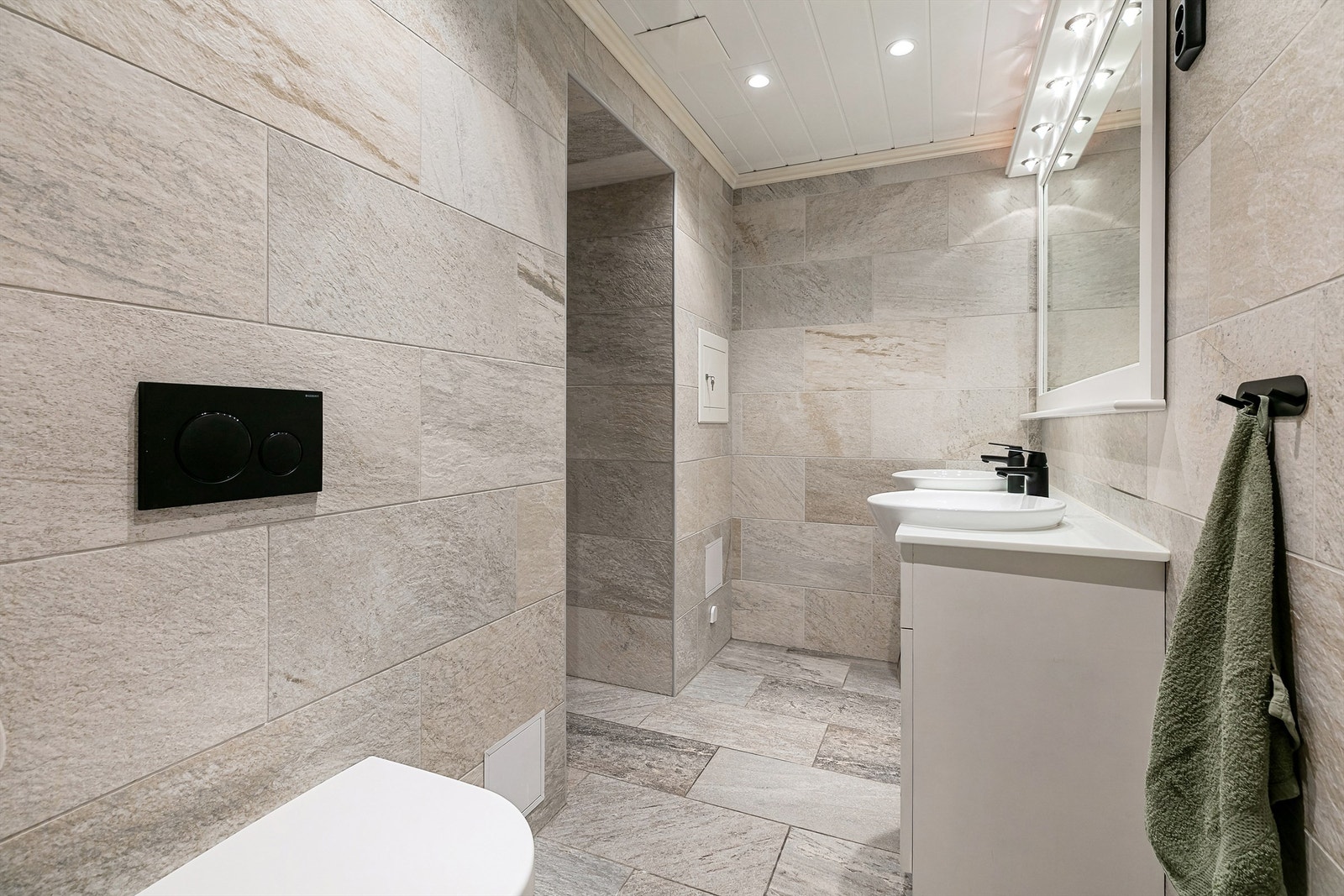 Flislagt bad i underetasjen med dusj inn til venstre Galleribilde