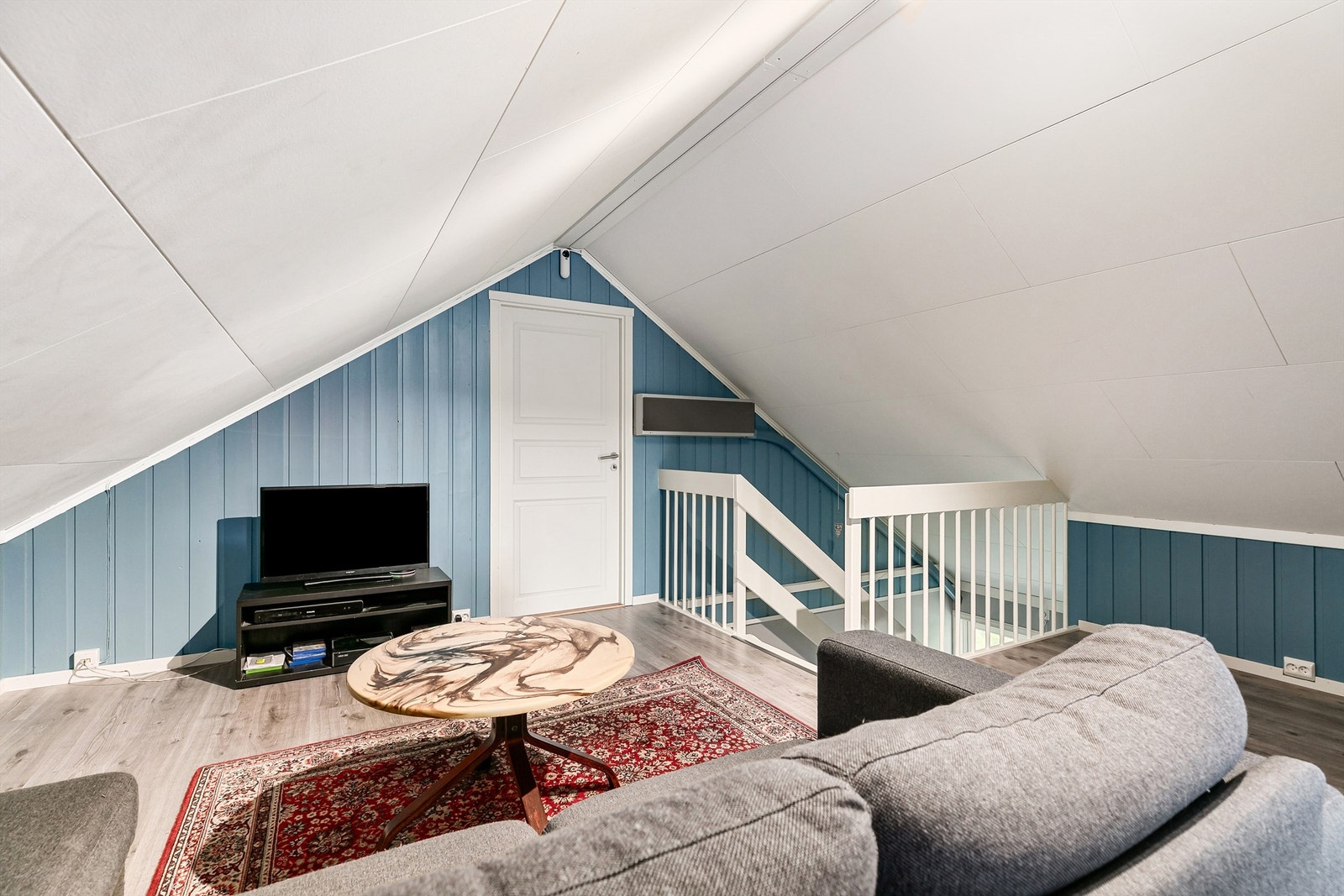 Loftstuen er lun og med plass for tv og en sofa. Galleribilde