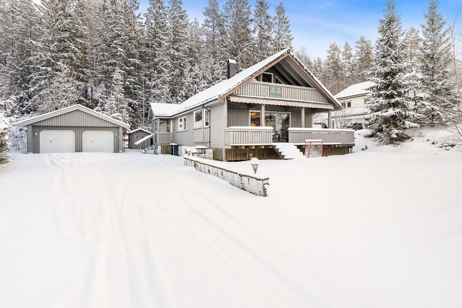 God plass på gårdsplassen med en stor dobbelt garasje. Galleribilde
