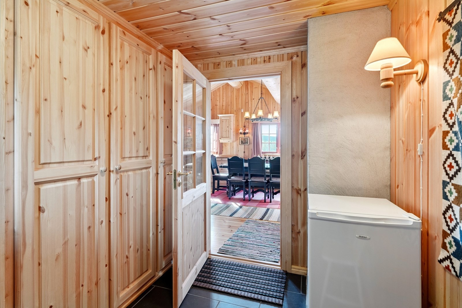 Fra det overbygde inngangspartiet kommer du inn i en praktisk entré med fliser og varmekabler i gulvet. Her er det plass til garderobeskap som gir god oppbevaring for sko og yttertøy. Galleribilde