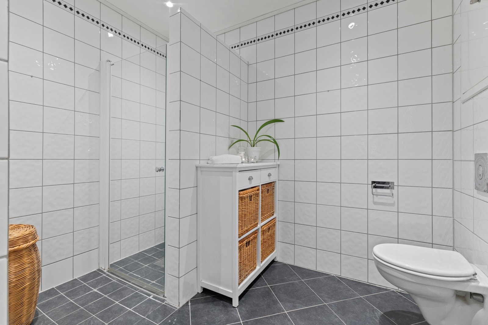 Pent baderom fra 2001 har flislagt gulv med varme som gir en behagelig start på dagen. Her finner du vegghengt servant med speil, dusjhjørne og vegghengt toalett med innebygget sisternekasse. Galleribilde