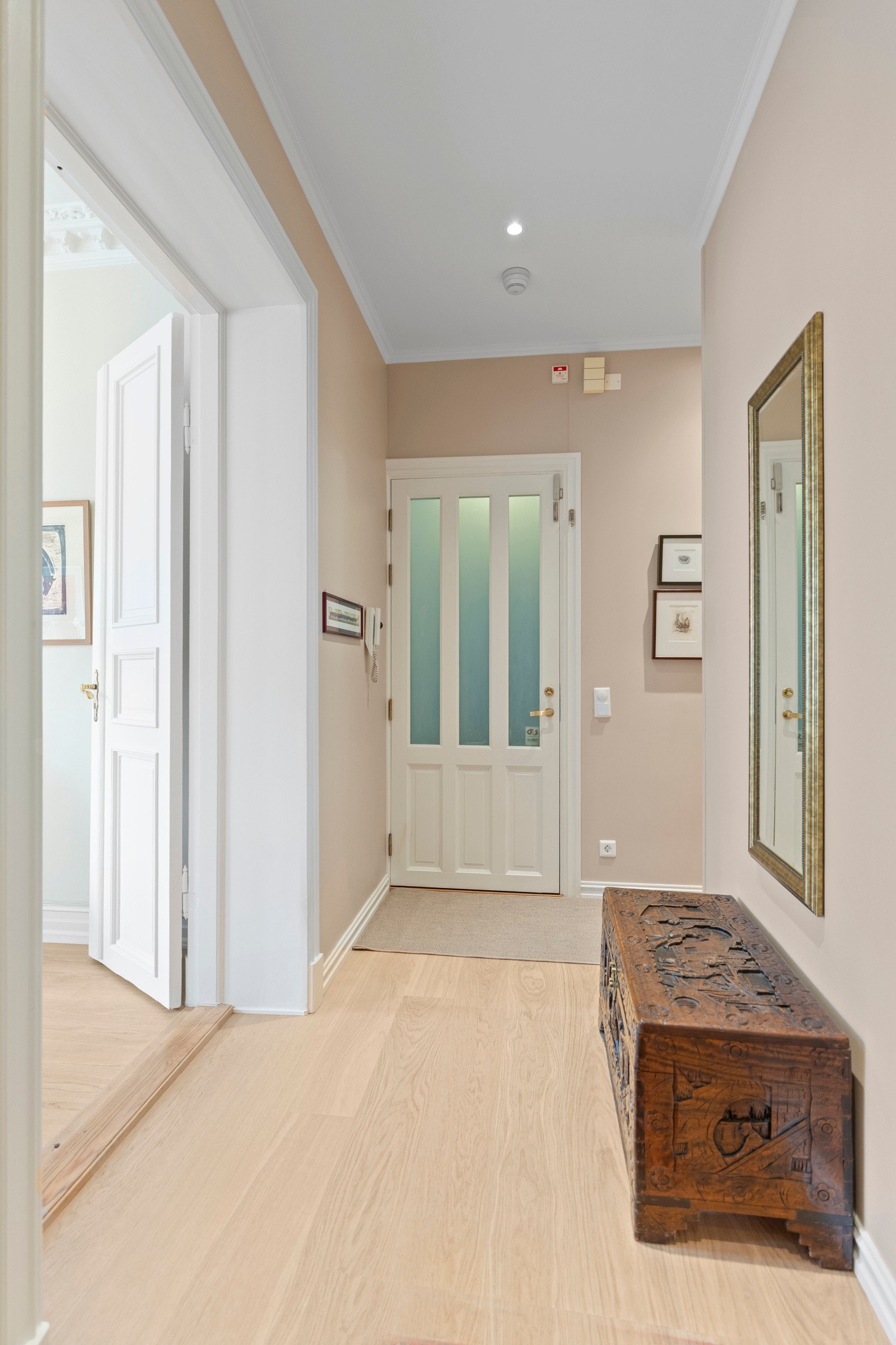 Velkommen inn! Allerede i entréen møtes du av en lys og innbydende atmosfære som setter tonen for resten av leiligheten. De lyse gulvene og de delikate, malte veggene gir et rent og elegant førsteinntrykk. Galleribilde