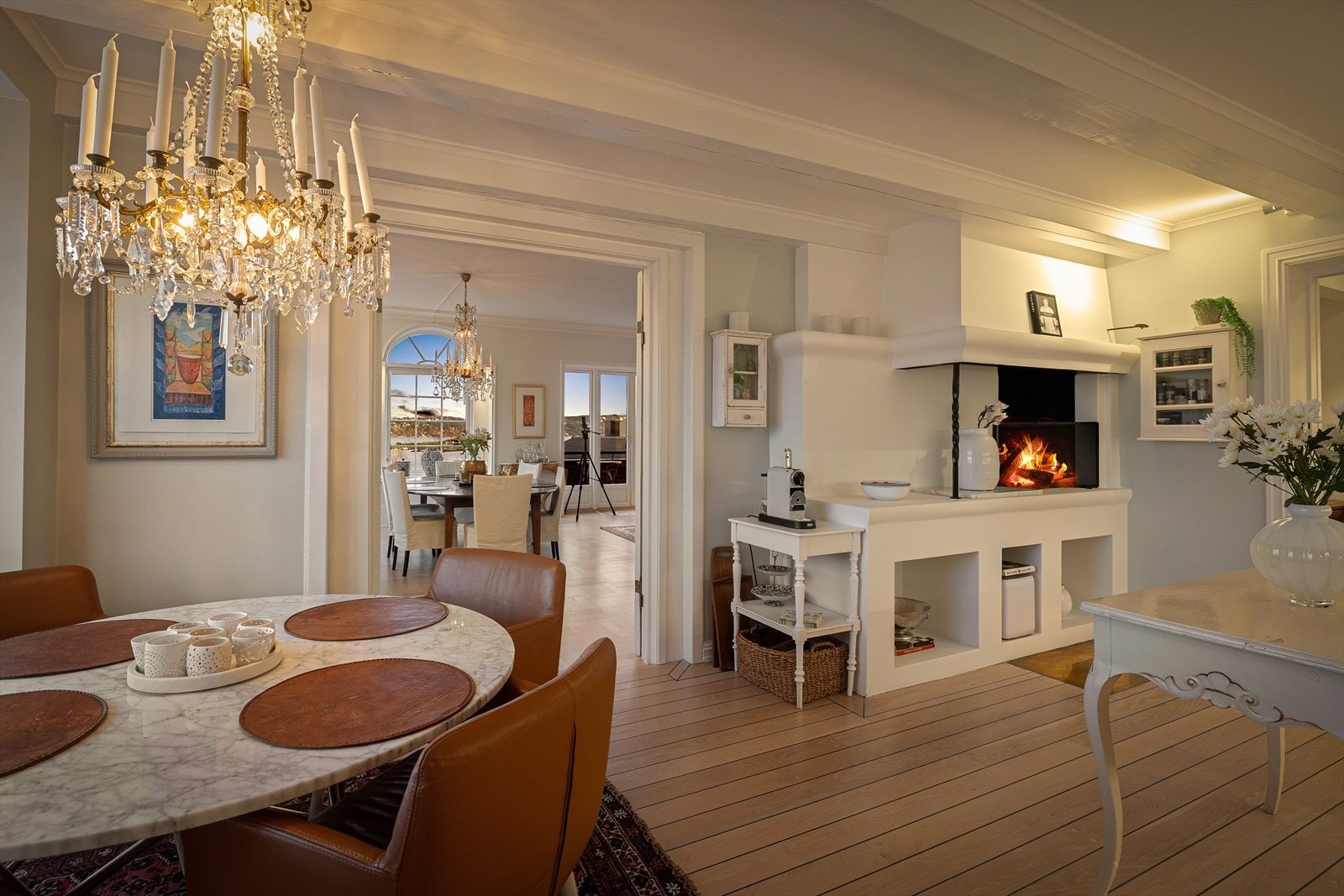 Taket er slett og malt, med taklampe, lys under overskap og spottlampe ved peisen som belysning. Galleribilde