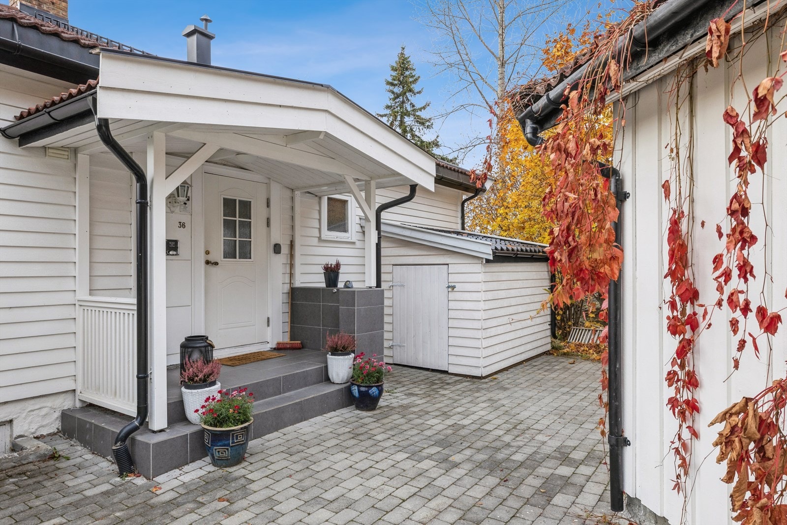 Et overbygget inngangsparti fører inn til boligens entré. Galleribilde