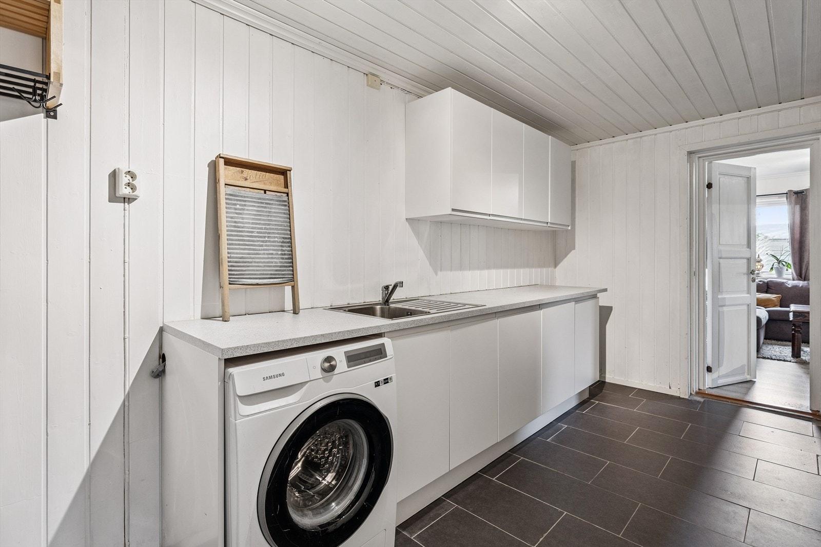 Separat vaskerom med praktisk benkeplate, utslagsvask og opplegg for vaskemaskin. Galleribilde