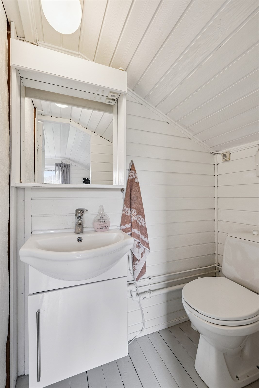 Praktisk toalettrom på loftet, innredet med servant og toalett. Galleribilde