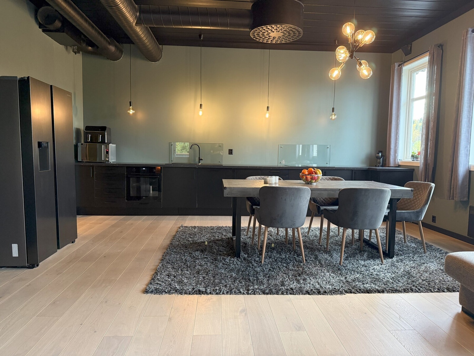 Romslig og luftig kjøkken med god takhøyde. Innredning med glatte fronter, laminat benkeplate, kompositt kum og praktiske integrerte hvitevarer. Galleribilde