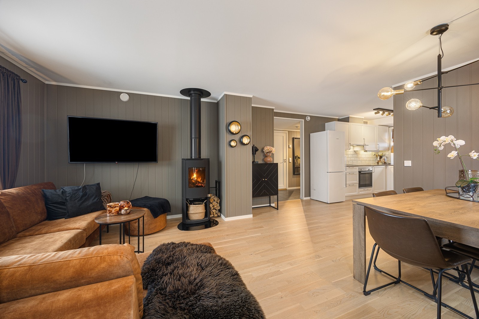 Lune kvelder sikres av en peisovn, plassert slik at stemningen nytes fra både sofakroken og spiseplassen. Galleribilde