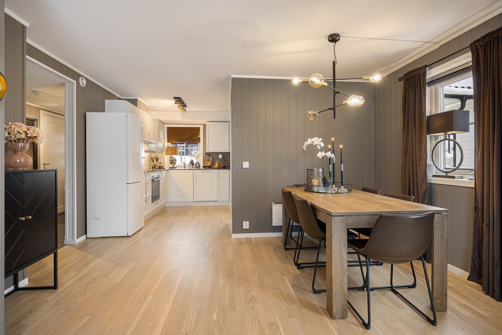 Sammen utgjør stuen og kjøkkenet et åpent, sosialt og innbydende allrom, der vinduer på to sider sørger for gode lys- og utsiktsforhold. Galleribilde