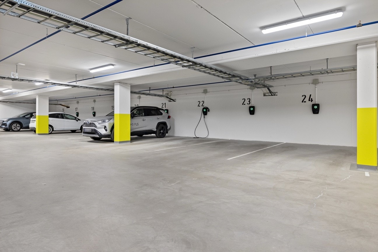 Med leiligheten følger parkeringsplass i lukket anlegg merket nr 14. Plassen er på enden og har kun bil på en side. Det er heisadkomst til både garasje i kjeller og 5 kvm bod i byggets 1. etasje. Galleribilde