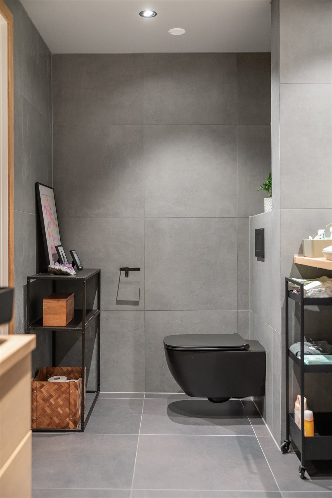 Store, grå fliser på vegger og gulv skaper et rolig og helhetlig rom. Galleribilde