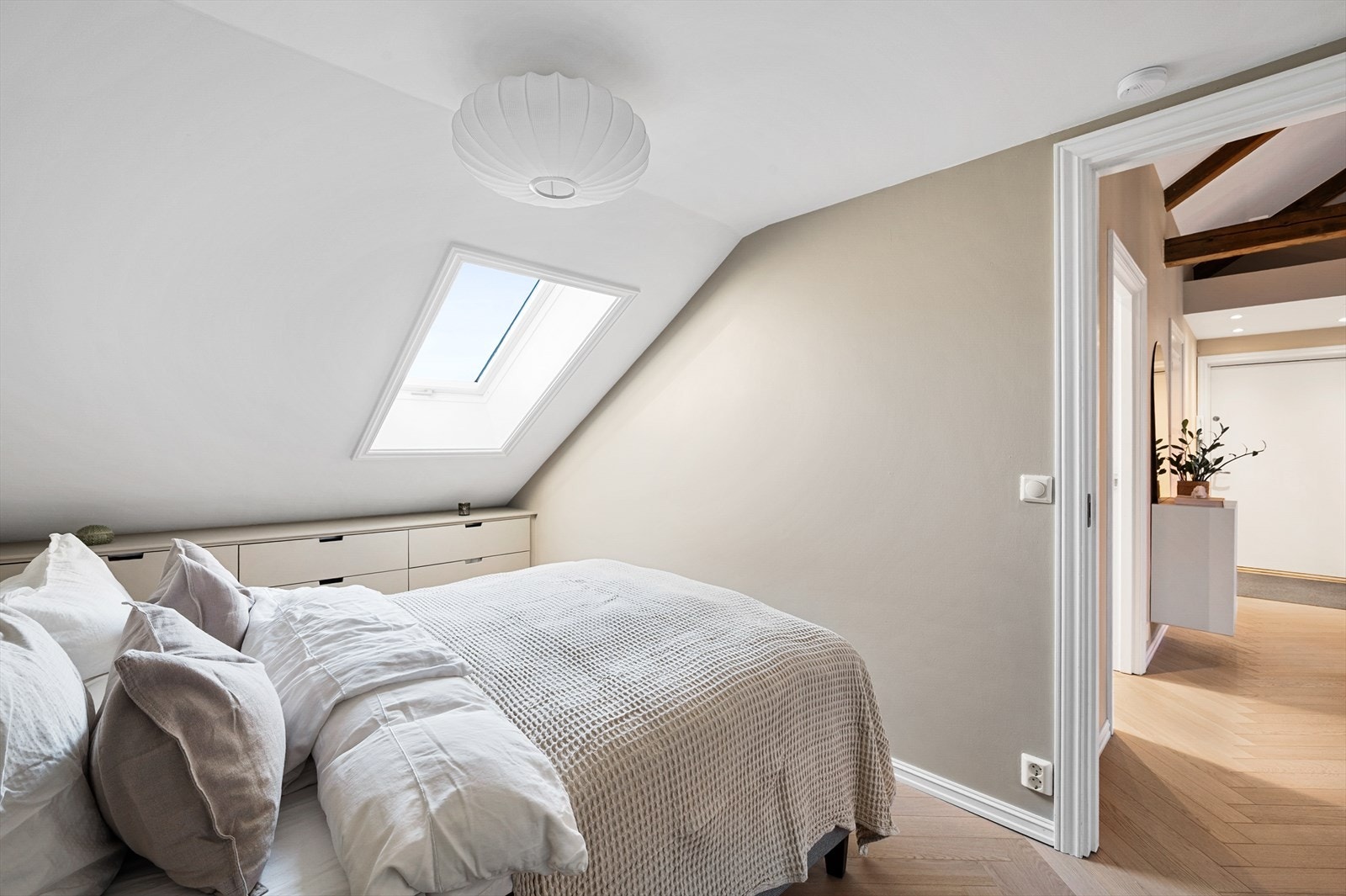 Pene overflater med hellimt fiskebensparkett og slette, malte veggflater - i tråd med resten av leilighetens helhetlige uttrykk Galleribilde