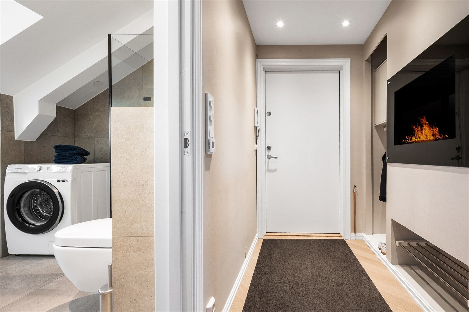 Entreen er adskilt fra stuen med en gjennomgående og stemningsfull biopeis. Integrerte oppbevaringsløsninger Galleribilde