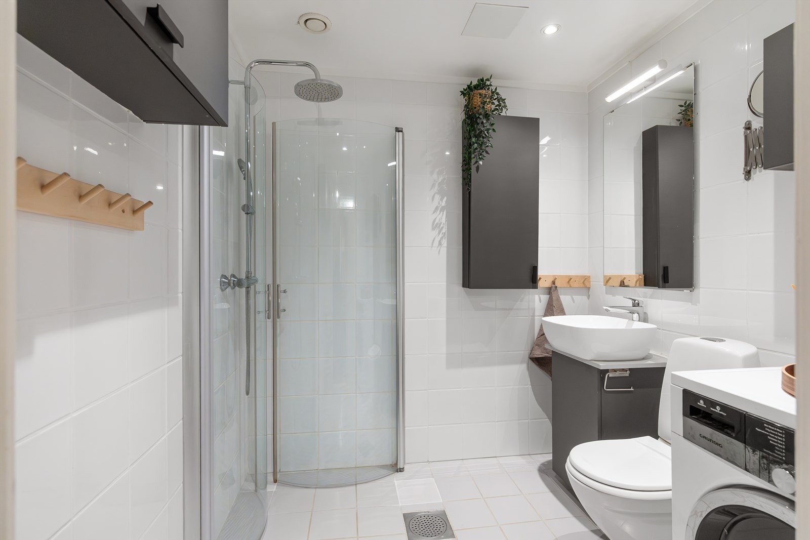 Badet er innredet med WC, dusjplass med inn- og utadslående dusjvegger, servant med ettgreps blandebatteri i baderomsinnredning. Galleribilde