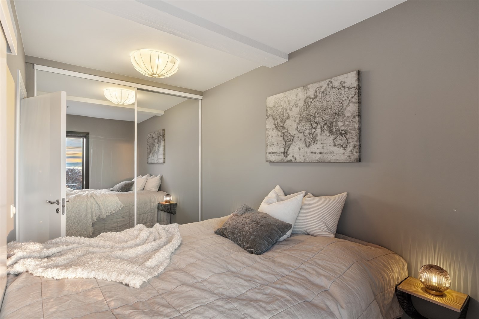 Rommet har også en romslig skyvedørsgarderobe med speilfronter, som gir rikelig med oppbevaringsplass og bidrar til en lys og romslig romfølelse. Galleribilde