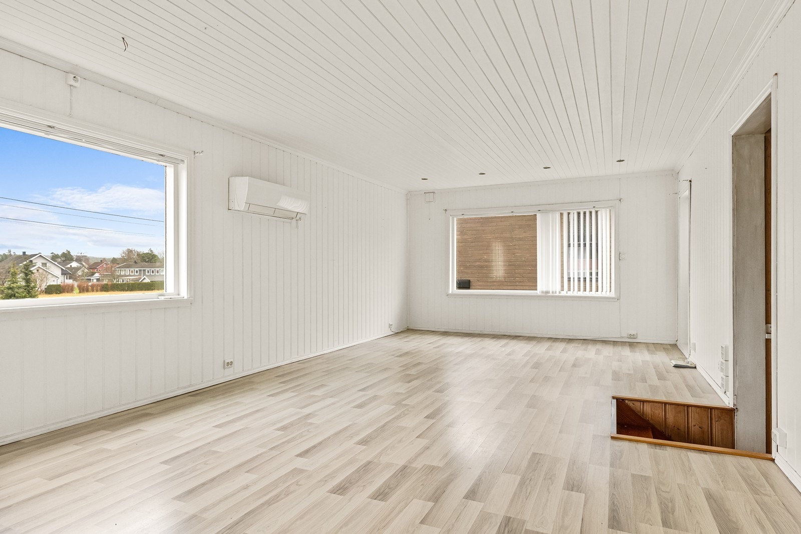 Videre fra entréen via gangen, kommer du inn i en romslig stue med gjennomgående laminatgulv. Galleribilde