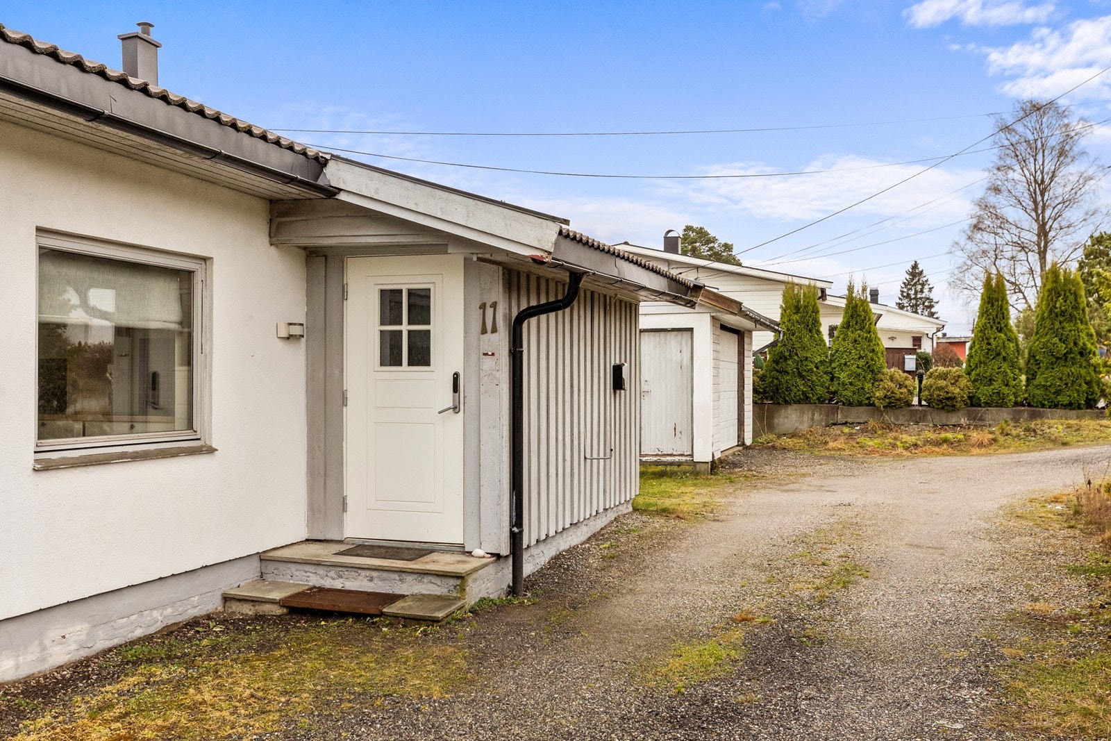 Inngangspartiet har en eldre, støpt trapp og utgangsdør med kodelås. Galleribilde