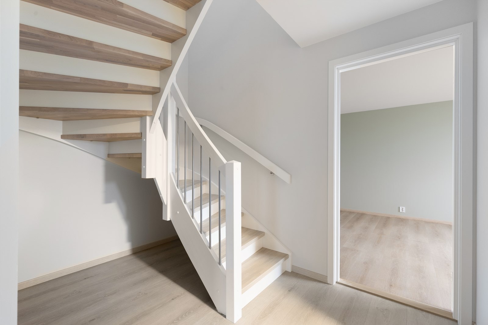 I gangen er det en svingtrapp med lakkerte eiketrinn opp til boligens 2. etasje. Rekkverket har stålspiler. Galleribilde