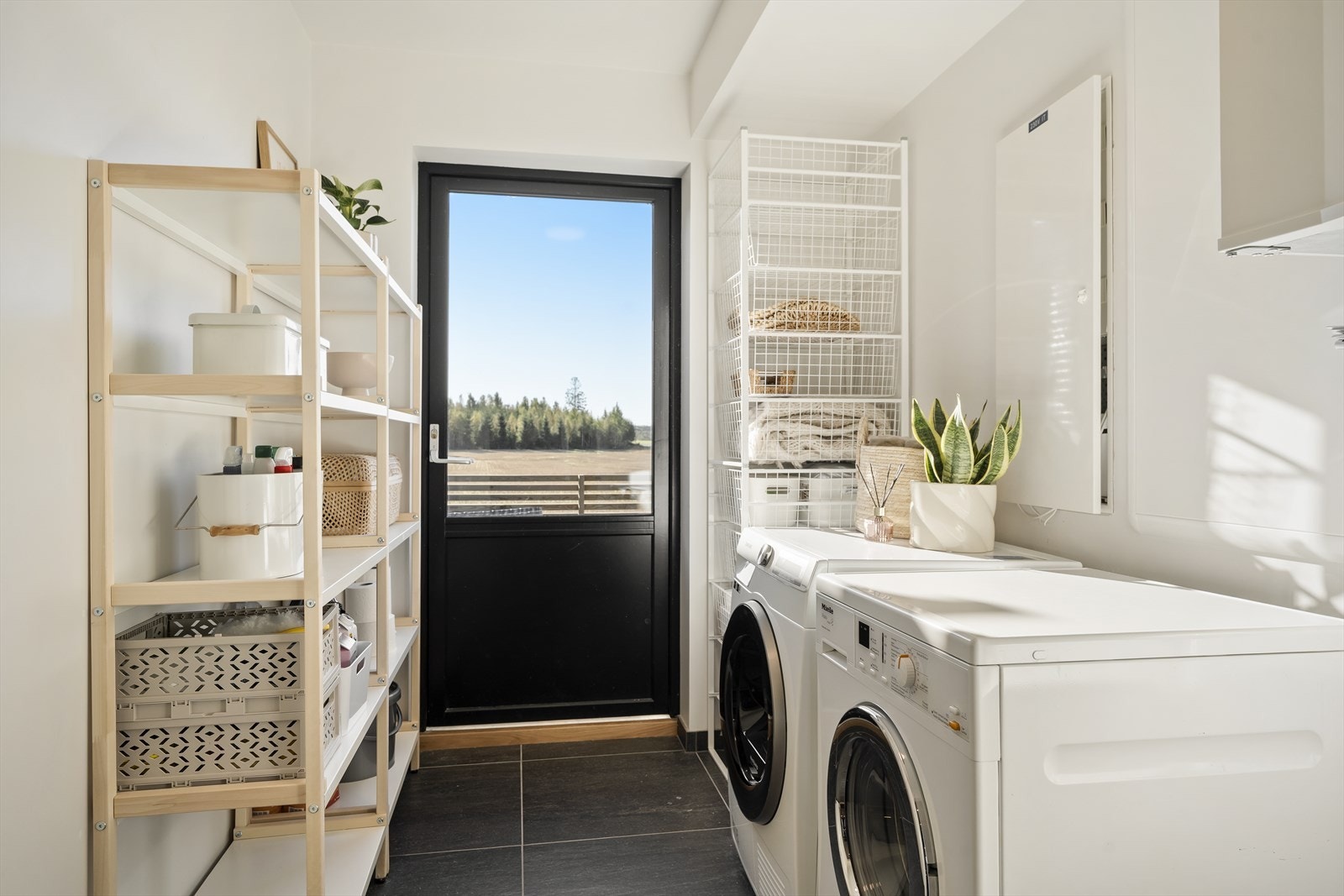 Vaskerom i praktisk tilknytning til gangen med egen utgang. Flislagt gulv med gulvvarme. Galleribilde