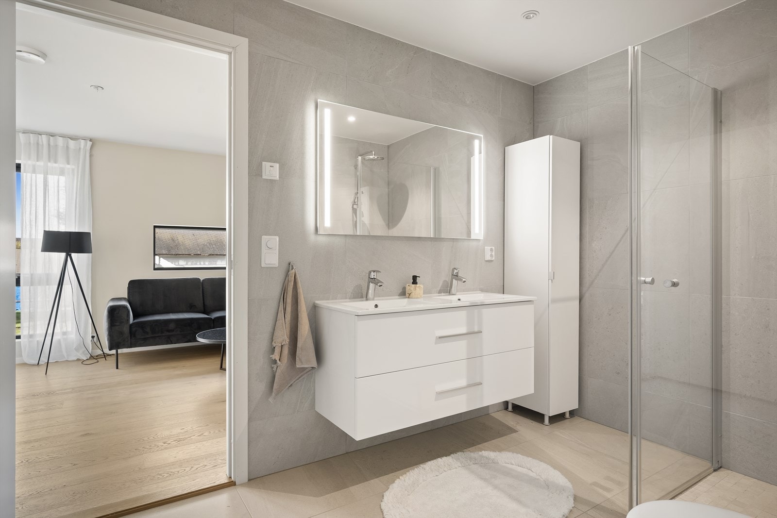 De to badene i boligen har gjennomgående stil med tidløse fargevalg på fliser og innredning. Galleribilde