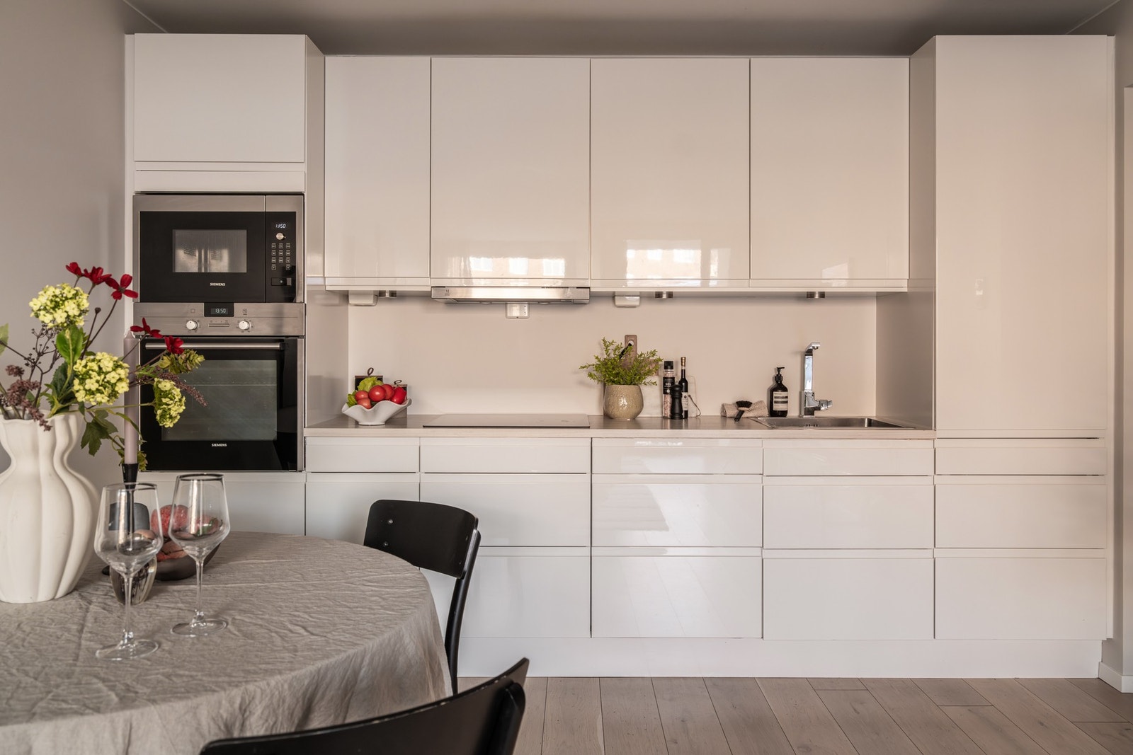 Kjøkkenet har et sømløst uttrykk med integrert oppvaskmaskin, kjøl/fryseskap, mikro, stekeovn og induksjon Galleribilde