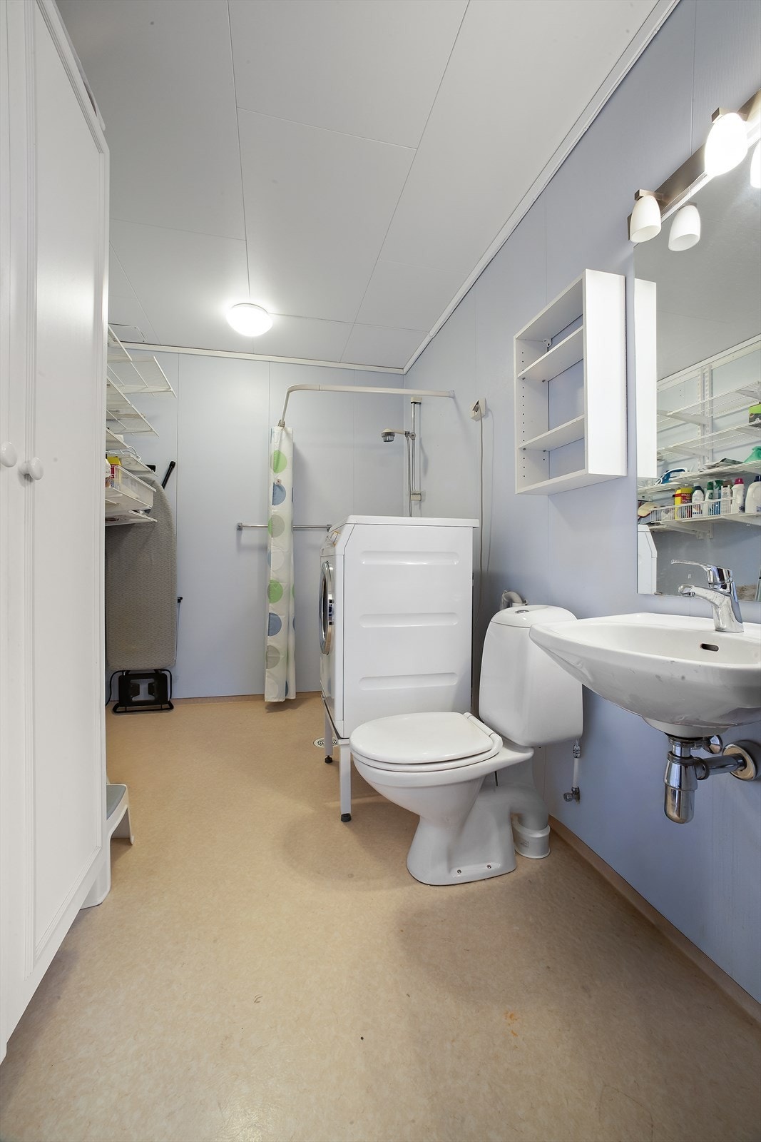 Badet i sokkeletasjen er utstyrt med veggmontert servant, gulvmontert toalett, dusjnisje med forheng, samt opplegg for vaskemaskin Galleribilde