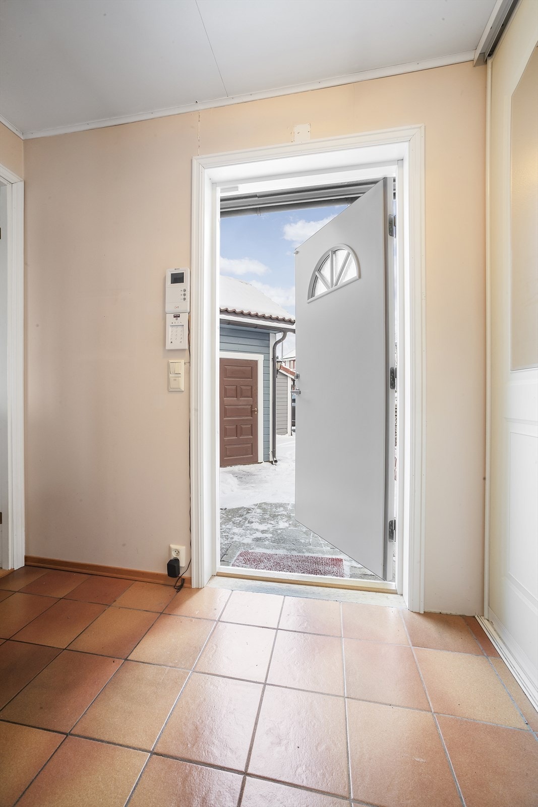 Man kommer inn i en lys flislagt entré Galleribilde