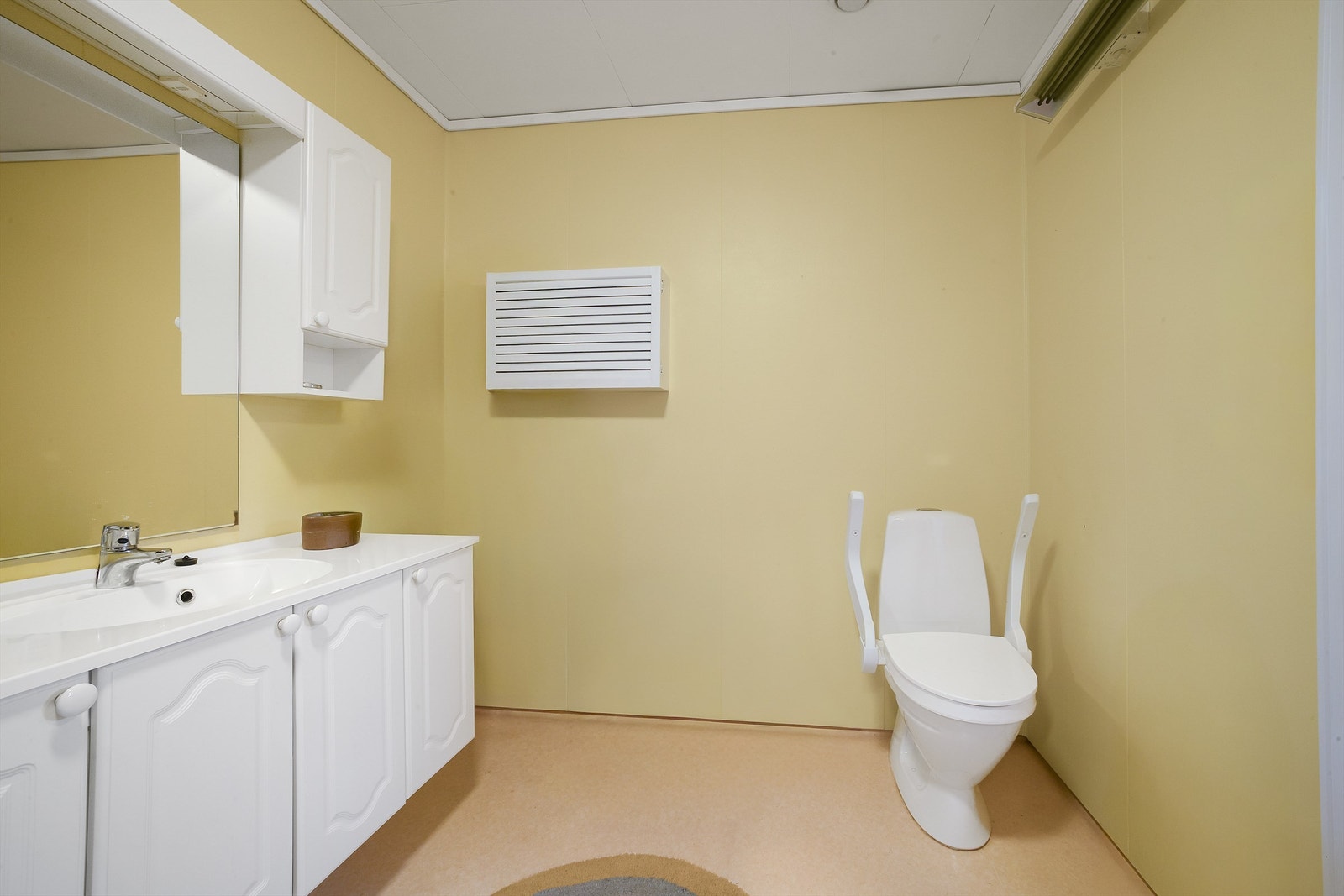 Badet i 1. etasje er fra byggeår og har vegger med baderomsplater Galleribilde