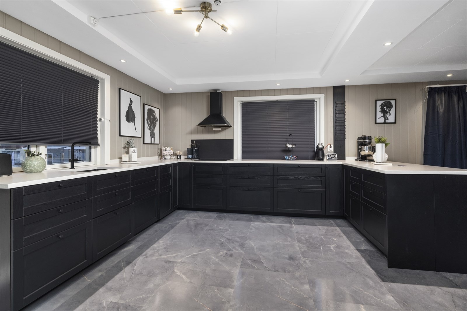 Kjøkkenet er utstyrt med integrert kjøleskap, fryseskap, oppvaskmaskin, induksjonstopp, stekeovn og komfyrvakt. Benkeplate av NeroStein i Kvarts. Galleribilde