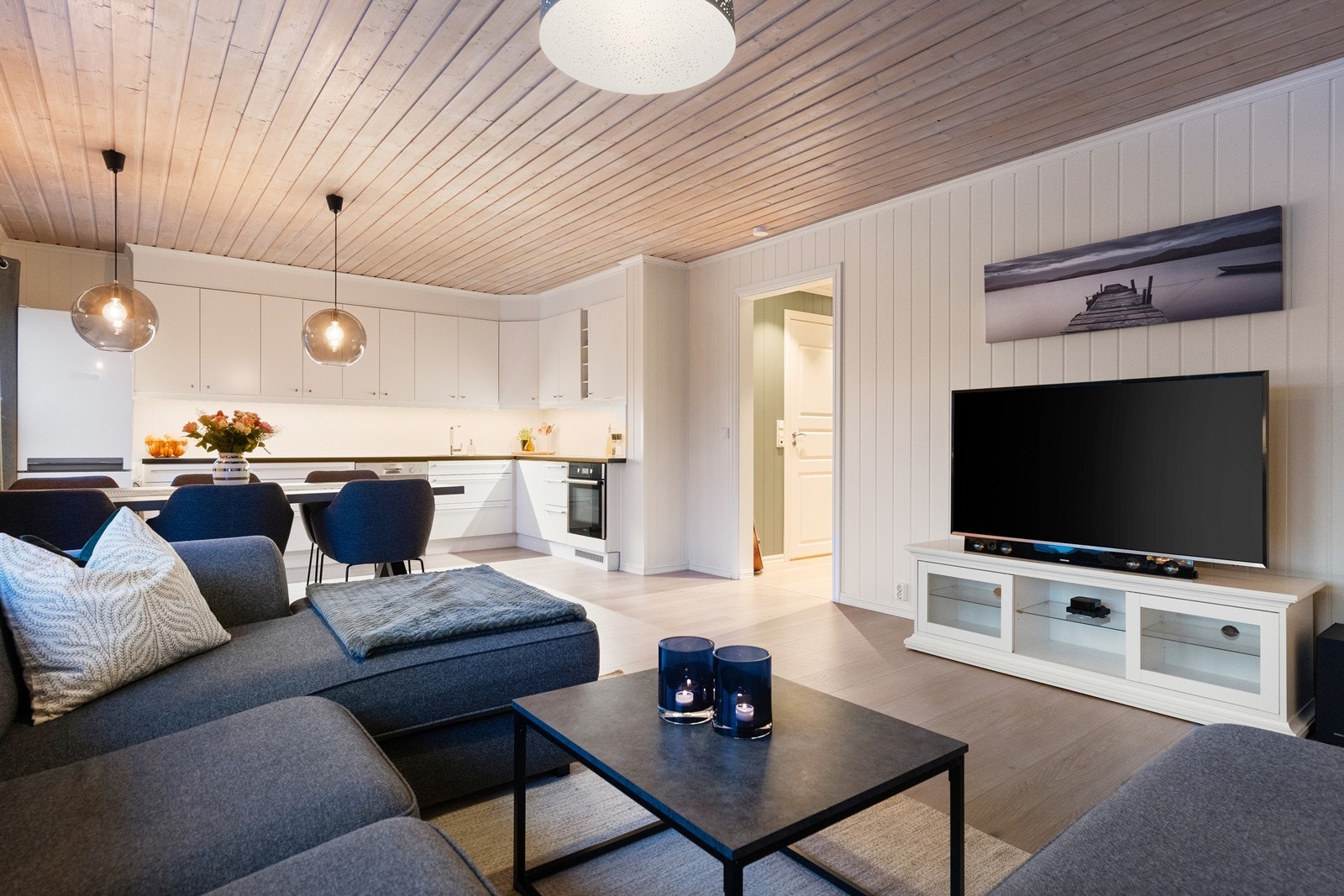 Leiligheten har en åpen og luftig planløsning mellom stue og kjøkken, noe som gir en sosial atmosfære Galleribilde