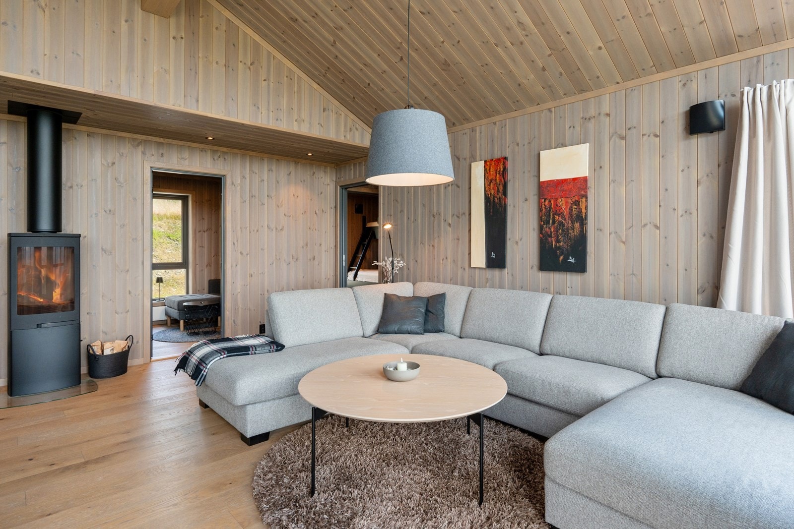 Midt i stua finner du en stemningsfull peisovn med glassdør - et naturlig samlingspunkt på kjølige kvelder. Galleribilde