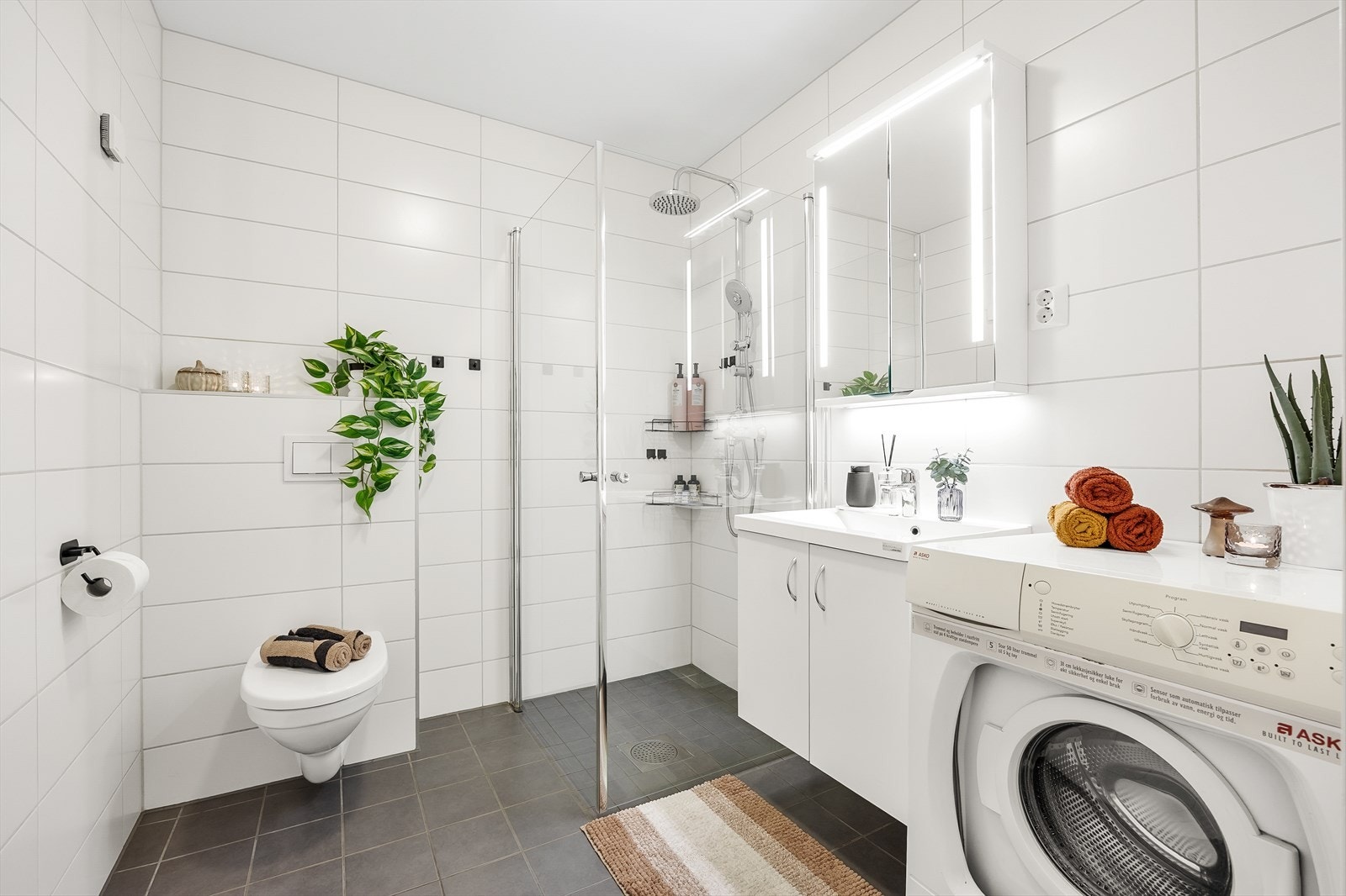 Badet fremstår delikat med flislagte overflater og lun gulvvarme. Galleribilde