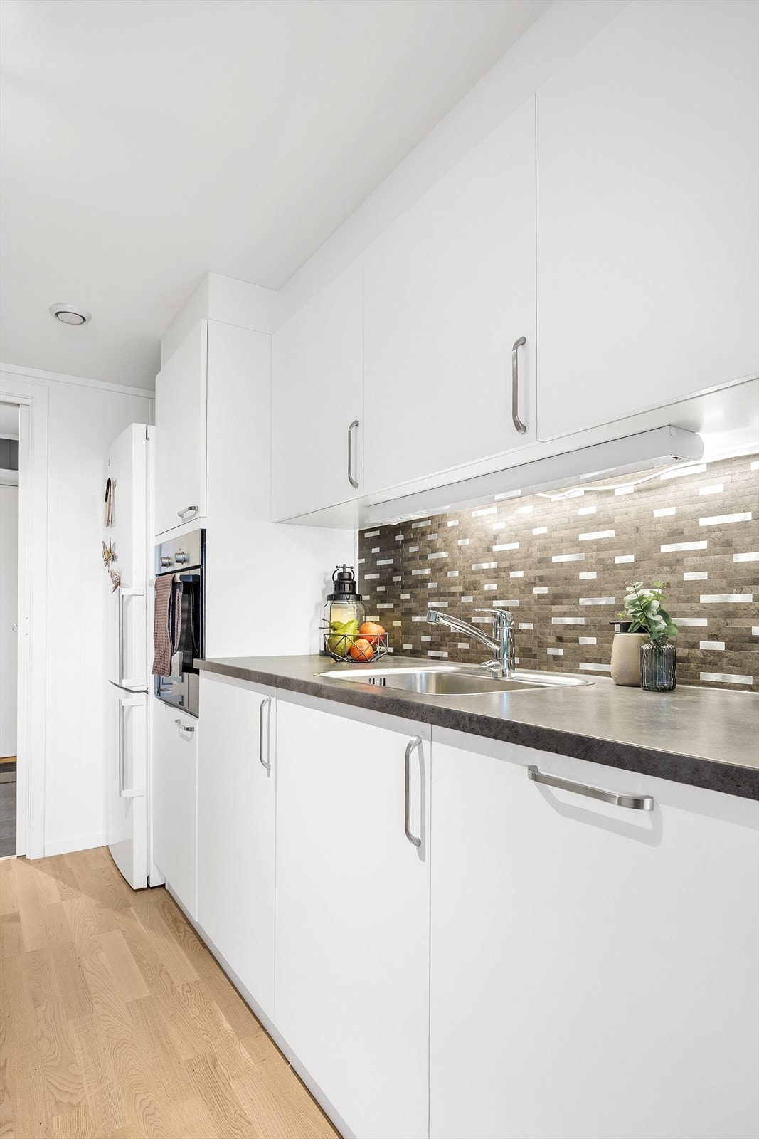 Kjøkkenet er holdt i tidløse farger som hvitt og grått. Galleribilde