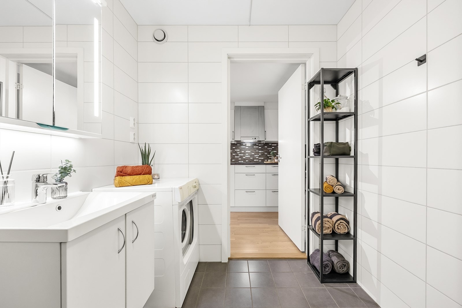 Videre har badet vegghengt toalett, dusjhjørne med innfellbare dører og regnfallsdusj, samt opplegg for vaskemaskin. Galleribilde