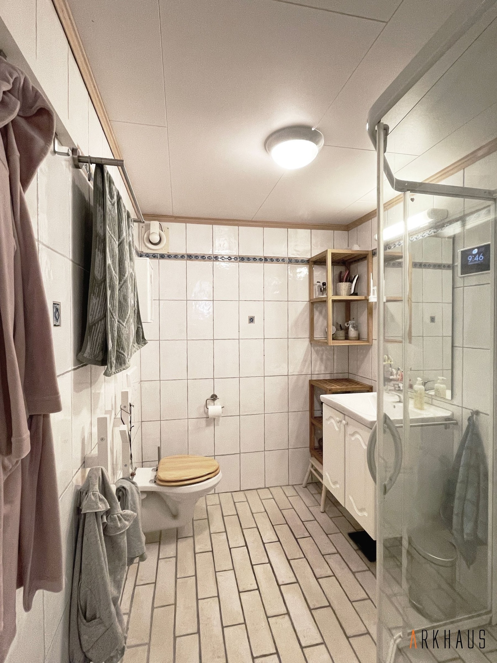 Fullt fungerende flislagt bad fra ca. 2005 med vegghengt toalett, vegghengte hyller og vegghengt servantskap Galleribilde