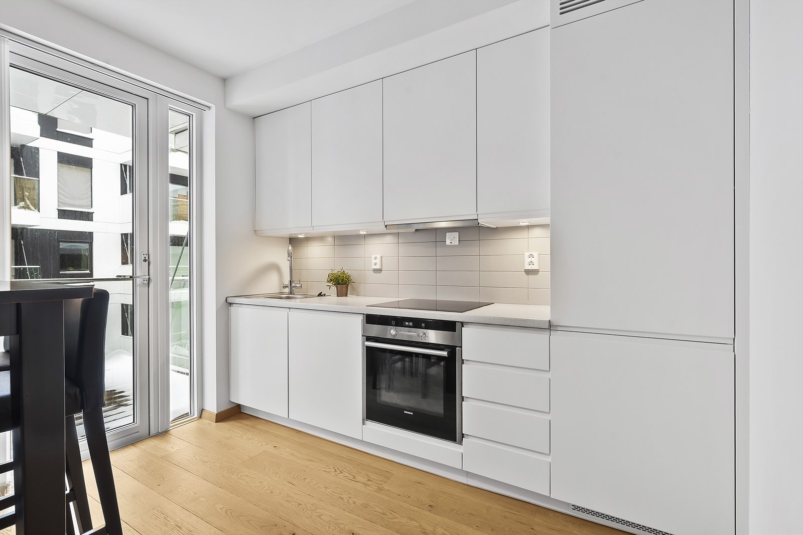 På kjøkkenet er det integrerte hvitevarer som stekeovn, steketopp, delvis skjult avtrekksvifte, oppvaskmaskin og kombiskap med kjøl og frys. Galleribilde