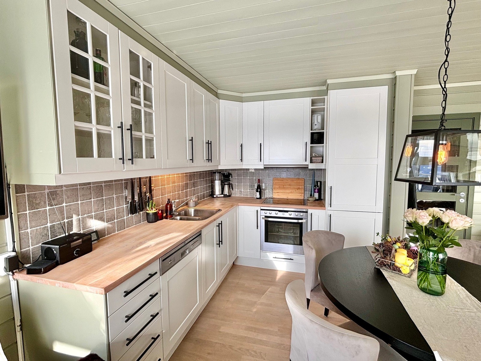 Åpen stue/ kjøkkenløsning. Kjøkkeninnredning med profilerte fronter og benkeplate i tre med nedfelt oppvaskkum. Galleribilde