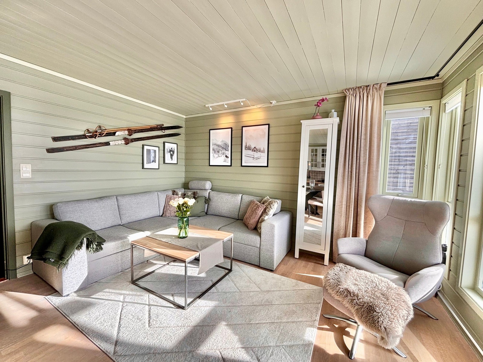 Lys stue med god plass til sofagruppe (sovesofa) med tilhørende møblement foran gasspeisen. Galleribilde