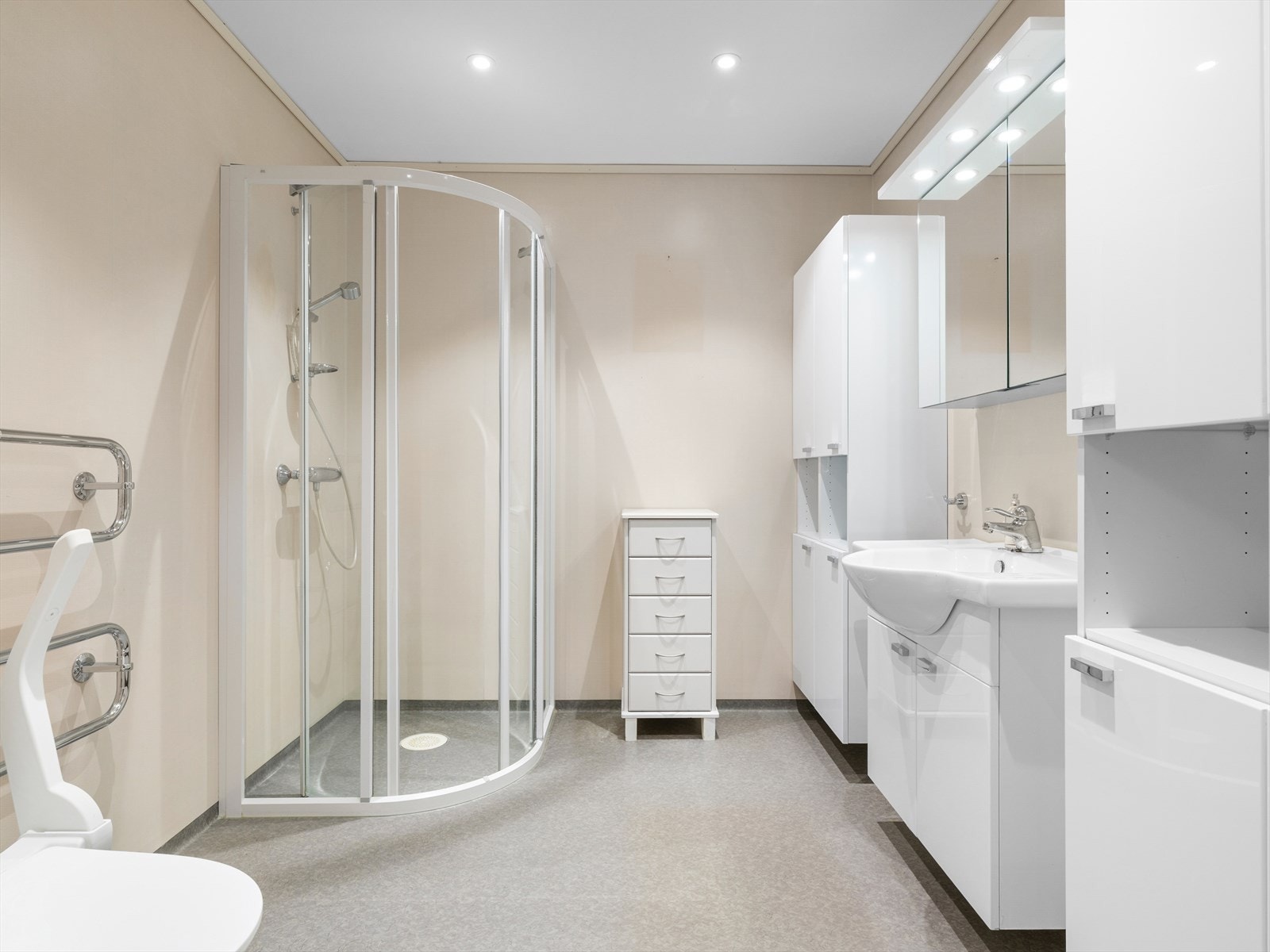 Praktisk bad med god lagringsplass i vegghengte seksjoner.
Vask og speilskap med belysning.
Wc og dusjhjørne. Galleribilde