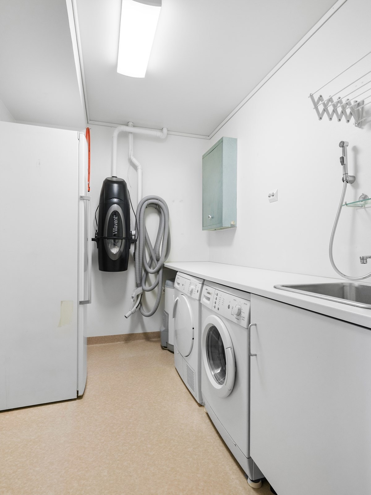 Innredet vaskerom med utslagsvask, benkeplate og plass til ekstra kjøleskap/frys.
Sentralstøvsuger montert. Galleribilde