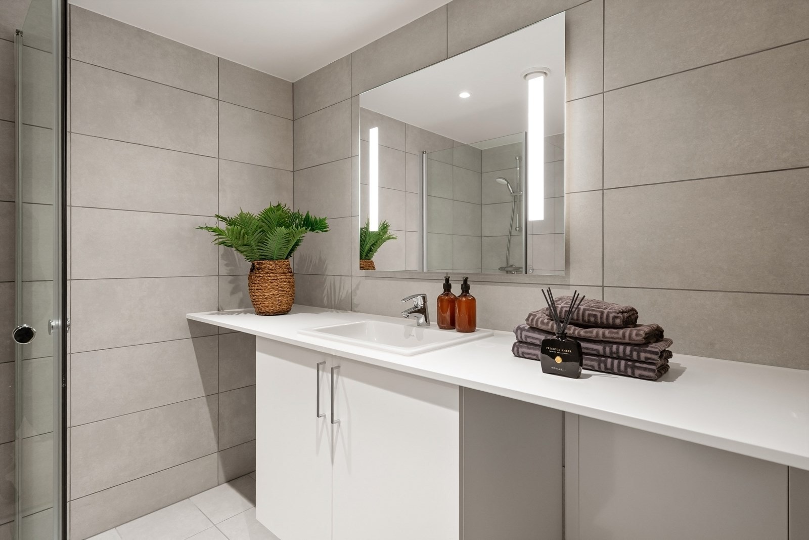 Romslig servantinnredning med rikelig benkeplass og skap. Praktisk nisje -og opplegg for- vaskemaskin. Galleribilde