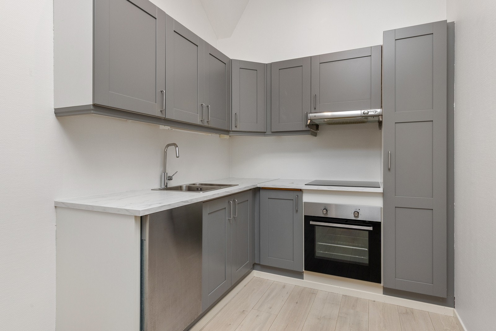 Det er oppvaskmaskin, platetopp og stekeovn. Nedfelt vask/kum i stål. Det er kjøkkenventilator med avtrekk ut. Galleribilde